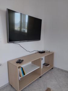 TV a schermo piatto seduta sopra un mobile con TV in legno di Apartments Tramonto a Bar