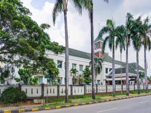 un edificio blanco con palmeras delante en Townhouse OAK Hotel Grand Cikarang, en Cikarang