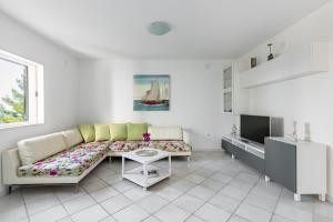 Sala de estar blanca con sofá y mesa en Apartments Croatia, en Trogir