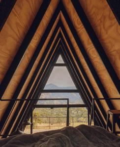 une chambre avec une grande fenêtre dans une tente dans l'établissement NOMADPLACE, à São Bento do Sapucaí