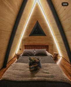 a bedroom with a large bed with a triangular ceiling at NOMADPLACE in São Bento do Sapucaí