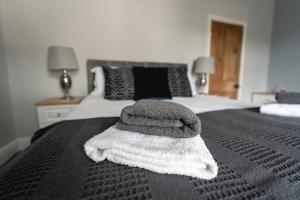 a pile of towels sitting on top of a bed at Seascape Cottage in Haverigg