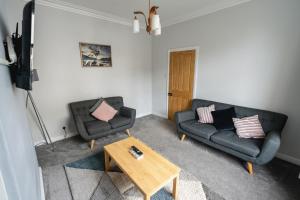 a living room with two couches and a coffee table at Seascape Cottage in Haverigg