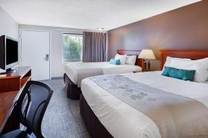 a hotel room with two beds and a television at Travelodge by Wyndham Monroe in Monroe