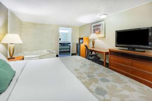 a hotel room with a bed and a flat screen tv at Travelodge by Wyndham Monroe in Monroe