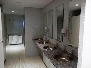a bathroom with two sinks and two mirrors at HI Vila do Conde - Pousada de Juventude in Vila do Conde +37 photos