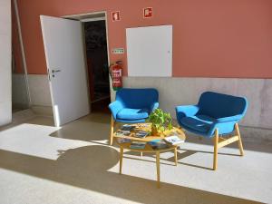 a living room filled with furniture and a blue couch at HI Vila do Conde - Pousada de Juventude in Vila do Conde