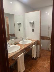 a bathroom with a sink, mirror, and towel rack at Parador de Las Cañadas del Teide in La Orotava