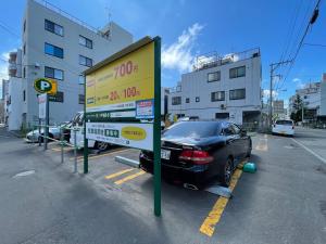 a sign in a parking lot with a car parked at （B10）NEW OPEN アクセス良好！リフォーム完了☆サービスアパ―トメントSAPPORO南8条B10 in Ōdōri