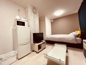 a small room with a refrigerator and a bed at （B10）NEW OPEN アクセス良好！リフォーム完了☆サービスアパ―トメントSAPPORO南8条B10 in Ōdōri