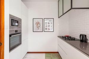 uma cozinha branca com um fogão e um micro-ondas em Casa da Avó em Chaves