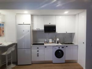eine Küche mit weißen Schränken und einer Waschmaschine in der Unterkunft NUE - Nuevo, 2 dormitorios, Wifi, Smart TV, Playa in Fuengirola