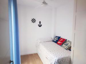 ein Zimmer mit einem Sofa und einer Uhr an der Wand in der Unterkunft NUE - Nuevo, 2 dormitorios, Wifi, Smart TV, Playa in Fuengirola