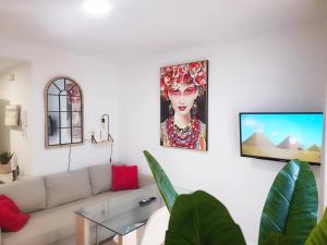 ein Wohnzimmer mit einem Sofa und einem Gemälde an der Wand in der Unterkunft NUE - Nuevo, 2 dormitorios, Wifi, Smart TV, Playa in Fuengirola