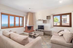 a living room with two couches and a television at Seaview Villas in Vourvourou