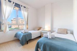 - une chambre avec 2 lits et une grande fenêtre dans l'établissement Piso 3 habitaciones plaza de garaje privada y gratuita, à Almería