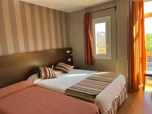 sypialnia z łóżkiem i oknem w obiekcie Hostal Los Coronales w Madrycie