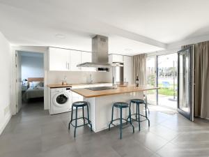 a kitchen with a sink and a counter with stools at Los Barqueros 16 by Best Holidays Fuerteventura in Corralejo