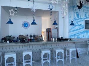 um bar com bancos brancos num restaurante em Beautiful 1-Bed Apartment em Hurghada