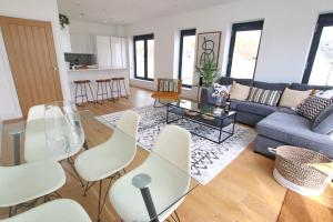 ein Wohnzimmer mit einem Glastisch und Stühlen in der Unterkunft Modern Home for Small Groups by Stones Throw Apartments - Free Parking - Sea View in Worthing