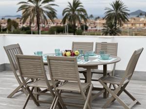 una mesa y sillas con un bol de fruta. en Outstanding 2 bed apartment with rooftop sea views en Mar de Cristal