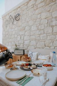 uma pessoa tirando uma foto de uma mesa com pratos de comida em paye alaçatı butik otel em Alacati