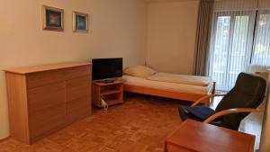 エッセンにあるApparthaus Arosaのベッド1台とテレビが備わる小さな客室です。