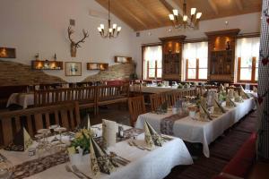 una sala da pranzo con tavoli con tovaglie bianche di Landhotel Kleblmühle a Grafenau