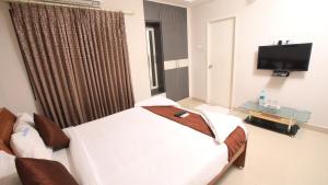 - une chambre à l'hôpital avec 2 lits et une télévision à écran plat dans l'établissement R-hotels Rithikha Inn porur, à Chennai