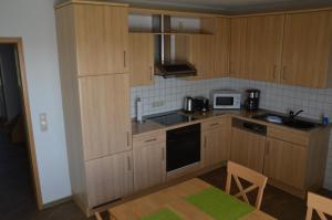 a kitchen with wooden cabinets and a stove top oven at Ferienhaus Tini in Wirdum