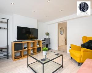 a living room with a television and a yellow couch at SPECIAL PROMO! Perfect Group Accommodation, 3 Bathrooms Perfect for Contractors and Businesses with relocation Requirement near Harwich Sea Port in Harwich