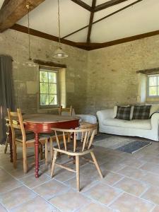 a living room with a table and chairs and a couch at Beautiful riverside boathouse in Bourg-Charente