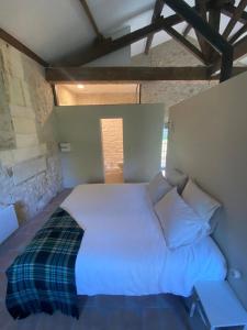 a bedroom with a white bed in a room at Beautiful riverside boathouse in Bourg-Charente