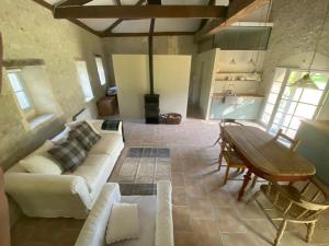 a living room with a couch and a table at Beautiful riverside boathouse in Bourg-Charente