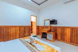 um quarto com uma cama, uma televisão e um espelho em Green Valley em Nusa Penida