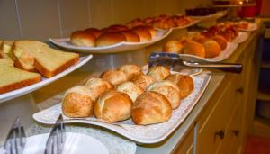 a buffet filled with plates of bread and pastries at TownHouse 33 in Milan