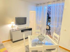 - un salon avec une télévision, une table et des chaises dans l'établissement Lovely apartment with pool, à Costa del Silencio
