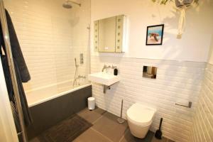 ein Badezimmer mit Waschbecken, Toilette und Badewanne in der Unterkunft Modern Home for Small Groups by Stones Throw Apartments - Free Parking - Sea View in Worthing