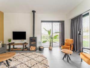 a living room with a fireplace and a tv at Nice water villa near forest, golf course and Veluwemeer in Zeewolde