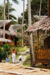 a woman walking down a path in front of a resort at Lazy Days Bungalows in Ko Lanta