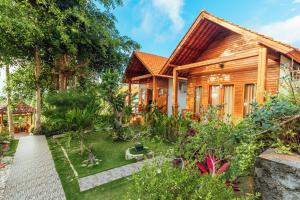 uma casa de madeira com um jardim em frente em Green Valley em Nusa Penida