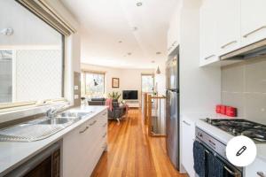 een keuken met een wastafel en een fornuis bij Design/bright/cosy townhouse between airport &city in Melbourne