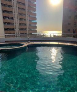 a swimming pool in front of two tall buildings at Flat number one temporadalitoranea in São Luís