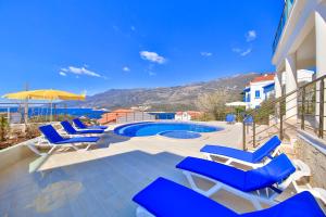 um grupo de cadeiras azuis e uma piscina em Blue Sea View Villas - Kas Peninsula em Kas