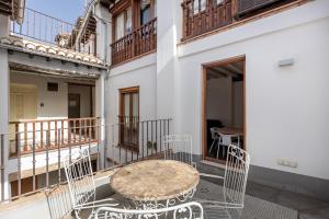 einen Tisch und Stühle auf dem Balkon eines Gebäudes in der Unterkunft Apartamentos Boutique Granada 3000 in Granada