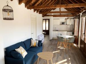 ein Wohnzimmer mit einem blauen Sofa und einem Tisch in der Unterkunft Apartamentos Boutique Granada 3000 in Granada