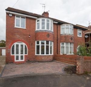 a red brick house with white windows and a driveway at Peace house - 56 Sycamore Terrace in York