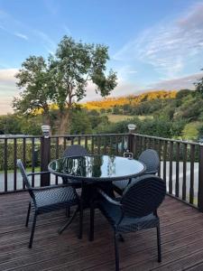 a table and chairs on a wooden deck with a view at Valley View Lodge in Welshpool