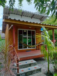 een klein huis met een houten veranda en een raam bij New Andaman Bay Bungalow in Koh Lanta
