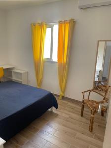 um quarto com uma cama, uma cadeira e um espelho em La Terrasse des manguiers em Saint-Denis